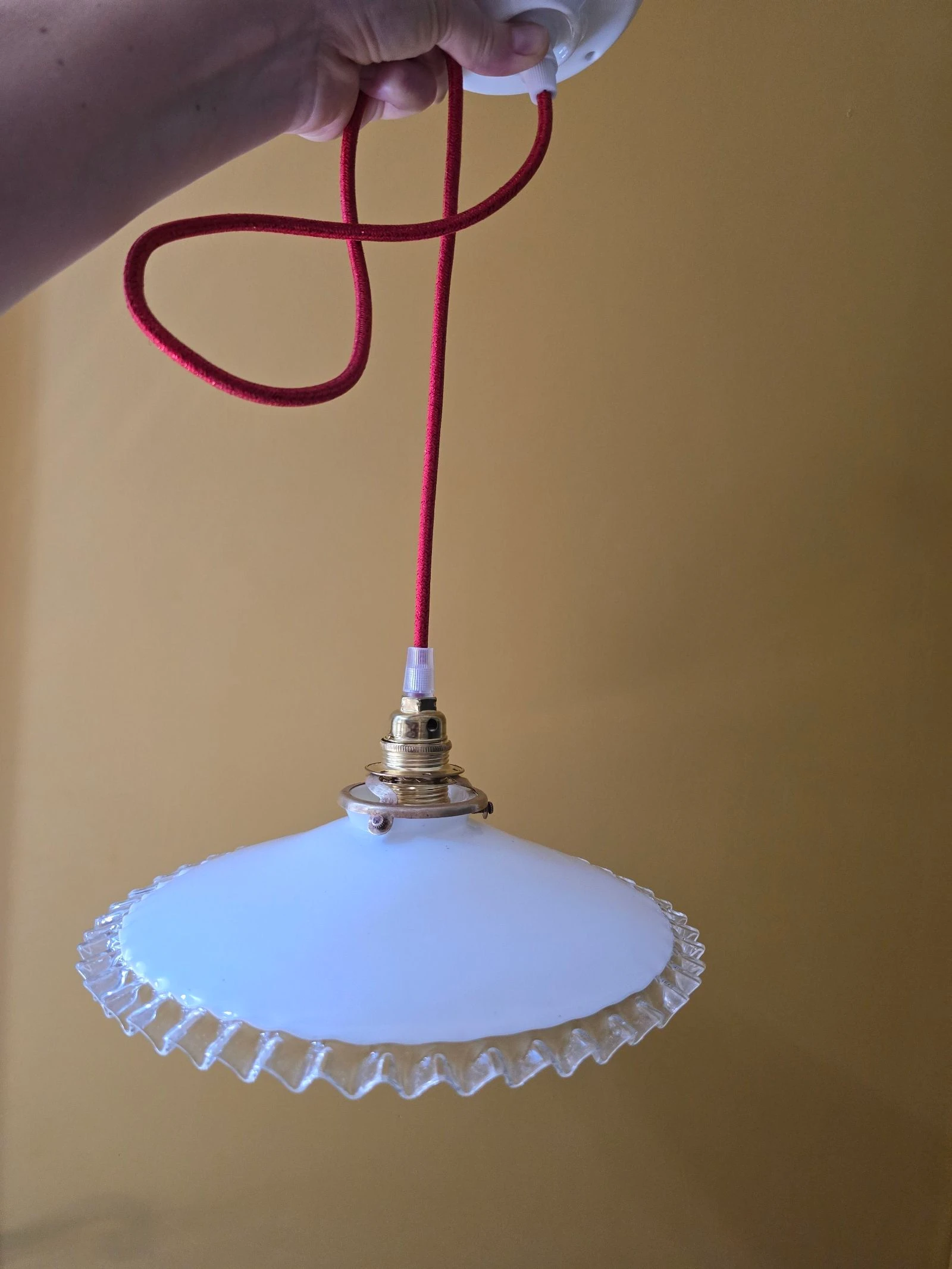 Lámpara de techo con disco opalino blanco y bordes transparentes sobre cable rojo y plafón de porcelana – photo 2